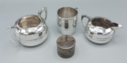 An Indian white metal two handled sucrier together with a matching cream jug, a white metal Niello