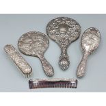 A Birmingham silver backed five piece dressing table set comprising two hand mirrors, two brushes