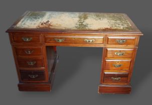 A late Victorian walnut twin pedestal desk, the tooled leather inset top above nine drawers with