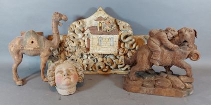 A carved wooden polychrome plaque depicting Putti amongst foliage together with a Black Forest model
