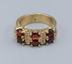 An 18ct gold Garnet and Diamond ring, set with six Garnets intersperse with diamonds, ring size J,