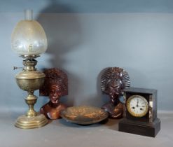 A Victorian black slate mantle clock together with a pair of African carved busts, an oil lamp and a