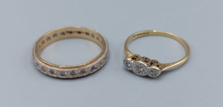 An 18ct gold three stone Diamond ring, 1.5g, together with a 9ct gold diamond set eternity ring, 2.