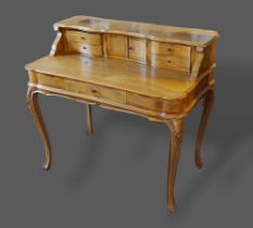 A 19th Century Continental walnut writing table, the superstructure with four drawers and central