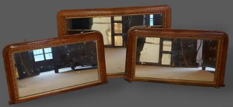 A pair of Victorian inlaid walnut wall mirrors, 48cms by 83cms, together with a similar larger