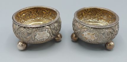 A pair of Victorian silver salts, with embossed decoration raised upon low feet, London 1883, 3ozs