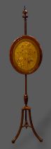 A 19th Century mahogany fire screen, the oval silkwork face screen above outswept legs with scroll