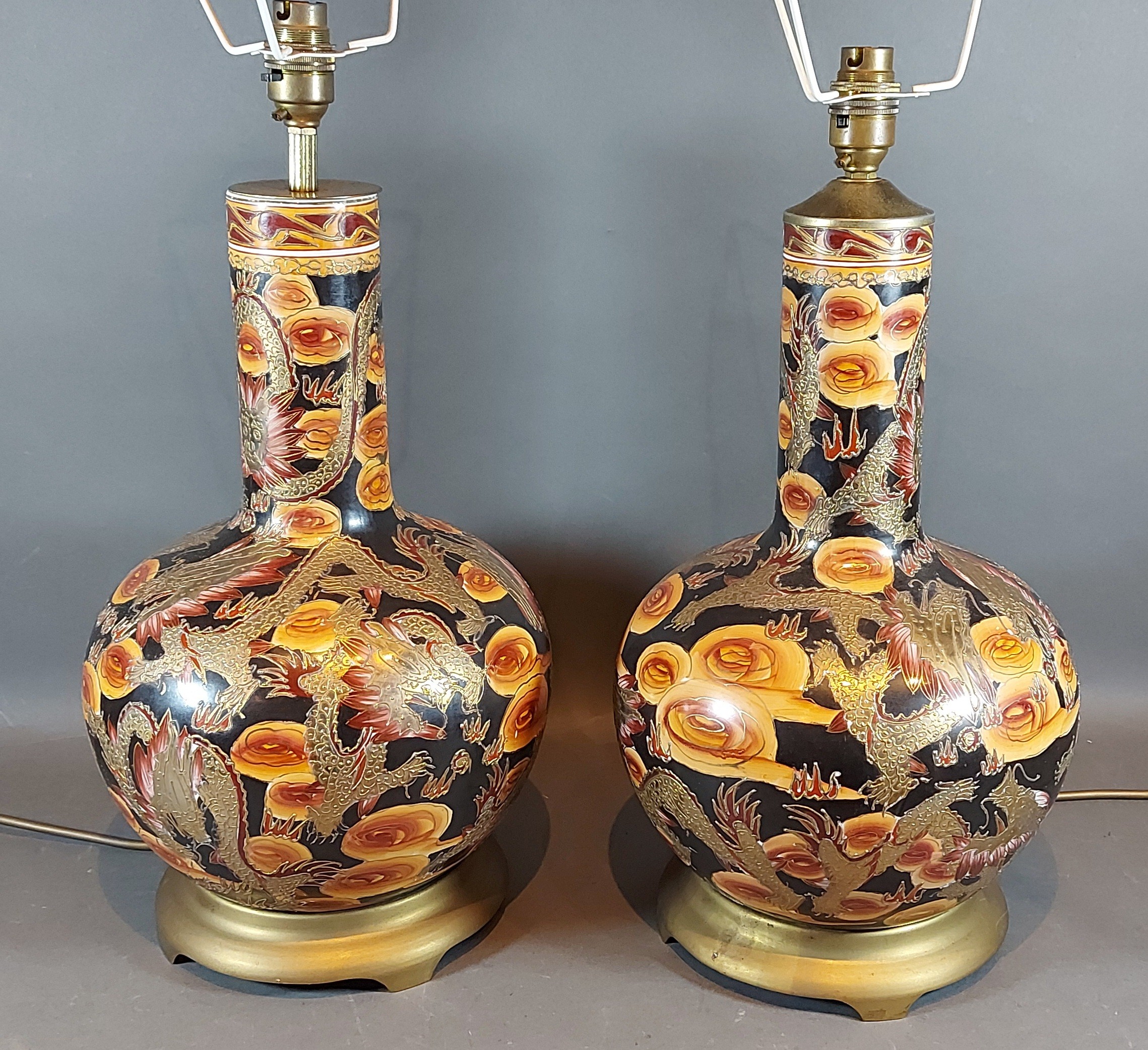 A pair of table lamps, decorated with serpents, upon gilt metal bases, 40cms tall
