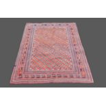 A woollen rug with all over design within multiple boarders, upon a red and cream ground, 147 by