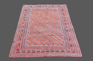 A woollen rug with all over design within multiple boarders, upon a red and cream ground, 147 by