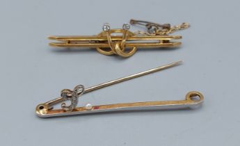 A 15ct gold bar brooch set with a diamond encrusted L and a single pearl together with another