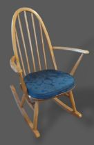 An Ercol blonde Ash rocking chair with spindle back above a panel seat