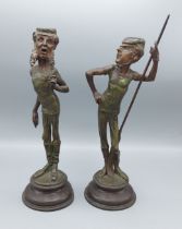 Emile Guillemin, a pair of patinated metal candlesticks, of stylised figural form, 31cms tall