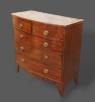 A mahogany bow fronted chest, the moulded top above two short and three long drawers with oval