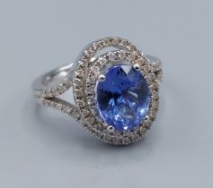 A 14ct white gold ring set with a Tanzanite surrounded by diamonds in a tiered form, diamonds 0.5ct,