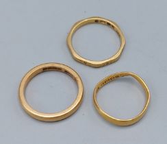 A 22ct gold wedding band, together with two other 22ct gold band rings, 8gms
