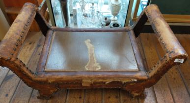 An antique large footstool, leather bonds have considerable wear, ideal for restoration.