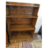 REGENCY DESIGN yew and mahogany 'Waterfall' style bookcase , with drawer base and brass castors,