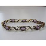 9CT YELLOW GOLD ANTIQUE AMETHYST & SEED PEARL BRACELET, very unusual ribbon & swag design, multi