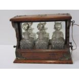 EDWARDIAN TANTALUS, a miniature oak triple bottle mirrored back tantalus with key, 24cm width