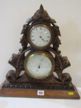 EDWARDIAN CLOCK BAROMETER, in foliate carved mahogany table top casing by Searle & Co. 41cm height