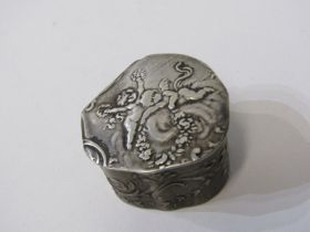 SILVER PILL BOX lid decorated with cherubs in relief, with foliate decoration to the body