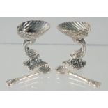 A PAIR OF SILVER DOLPHIN SALTS AND SPOONS.