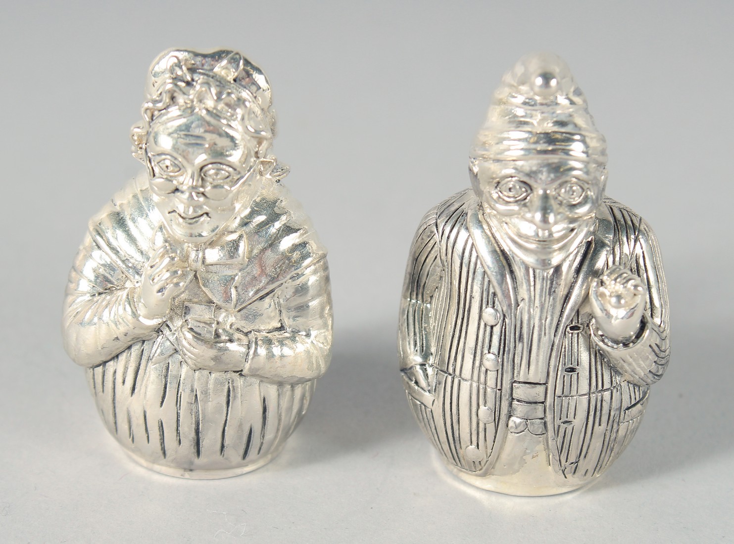 A PAIR OF SILVER PLATED PUNCH AND JUDY SALT AND PEPPERS, 5 cm.