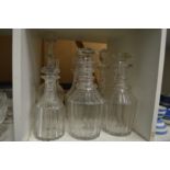 A pair of cut glass decanters and four others.