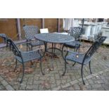 An aluminium circular patio table with four armchairs.