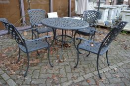 An aluminium circular patio table with four armchairs.