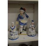 A Continental painted porcelain figure of a boy selling goods from his apron together with a pair of