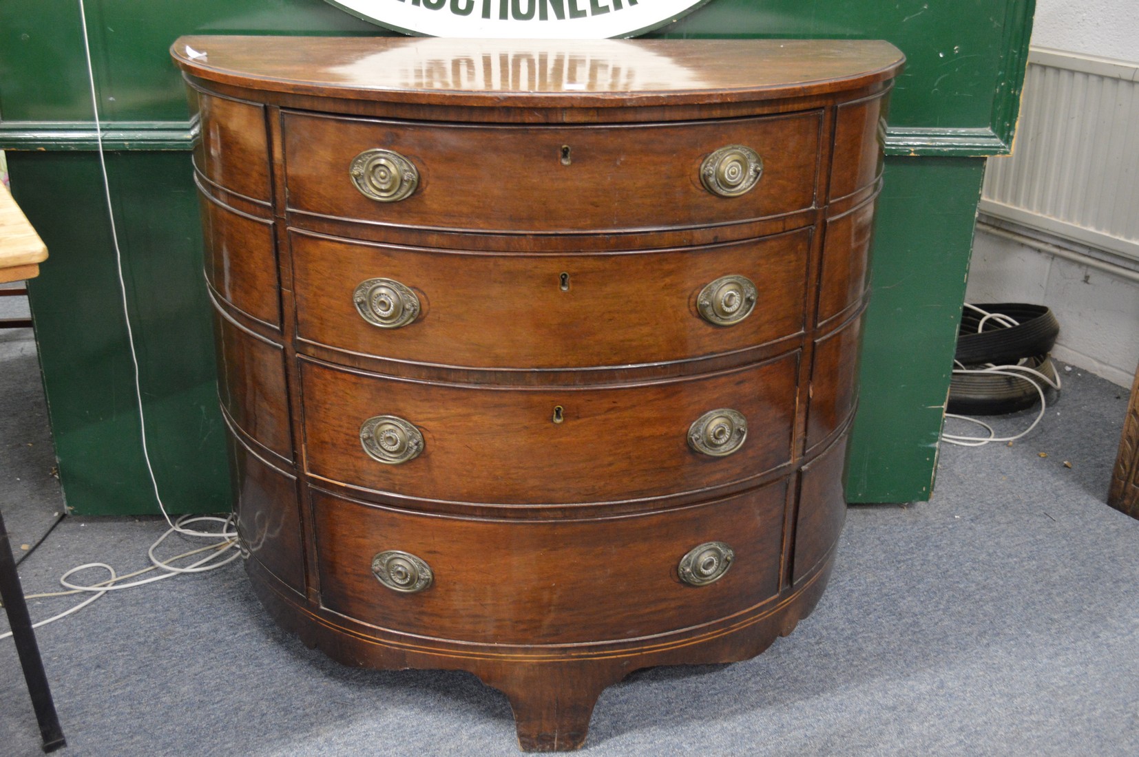 A George III mahogany demi lune four drawer chest.