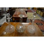Three glass decanters and stoppers.
