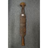 An Eastern carved wood paddle or club.