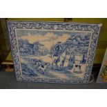 A blue and white porcelain tile picture depicting a man on horseback with hounds.