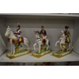 Three porcelain figures on horseback.