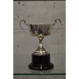 A silver pedestal trophy cup.