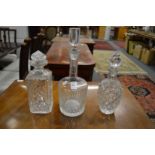 Three cut glass decanters and stoppers.