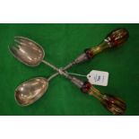 A pair of plated salad servers with cut glass handles.