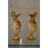 A near pair of Royal Worcester blush ivory miniature ewers with floral decoration.