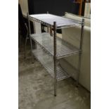 A chrome wire three tier shelving unit.