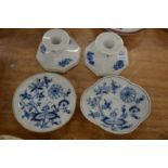 A pair of Copenhagen candlesticks and two Meissen blue and white saucers.