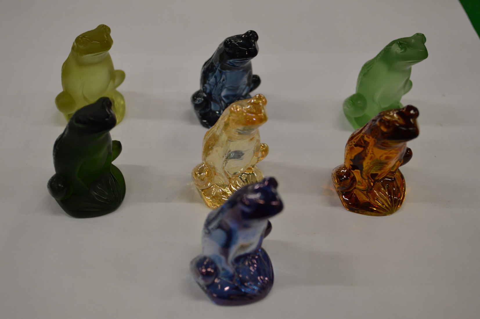 Seven Lalique opaque glass seated frogs.