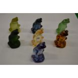 Seven Lalique opaque glass seated frogs.