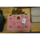 A ladies pink velvet handbag.