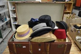 A large trunk containing numerous hats.