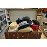 A large trunk containing numerous hats.