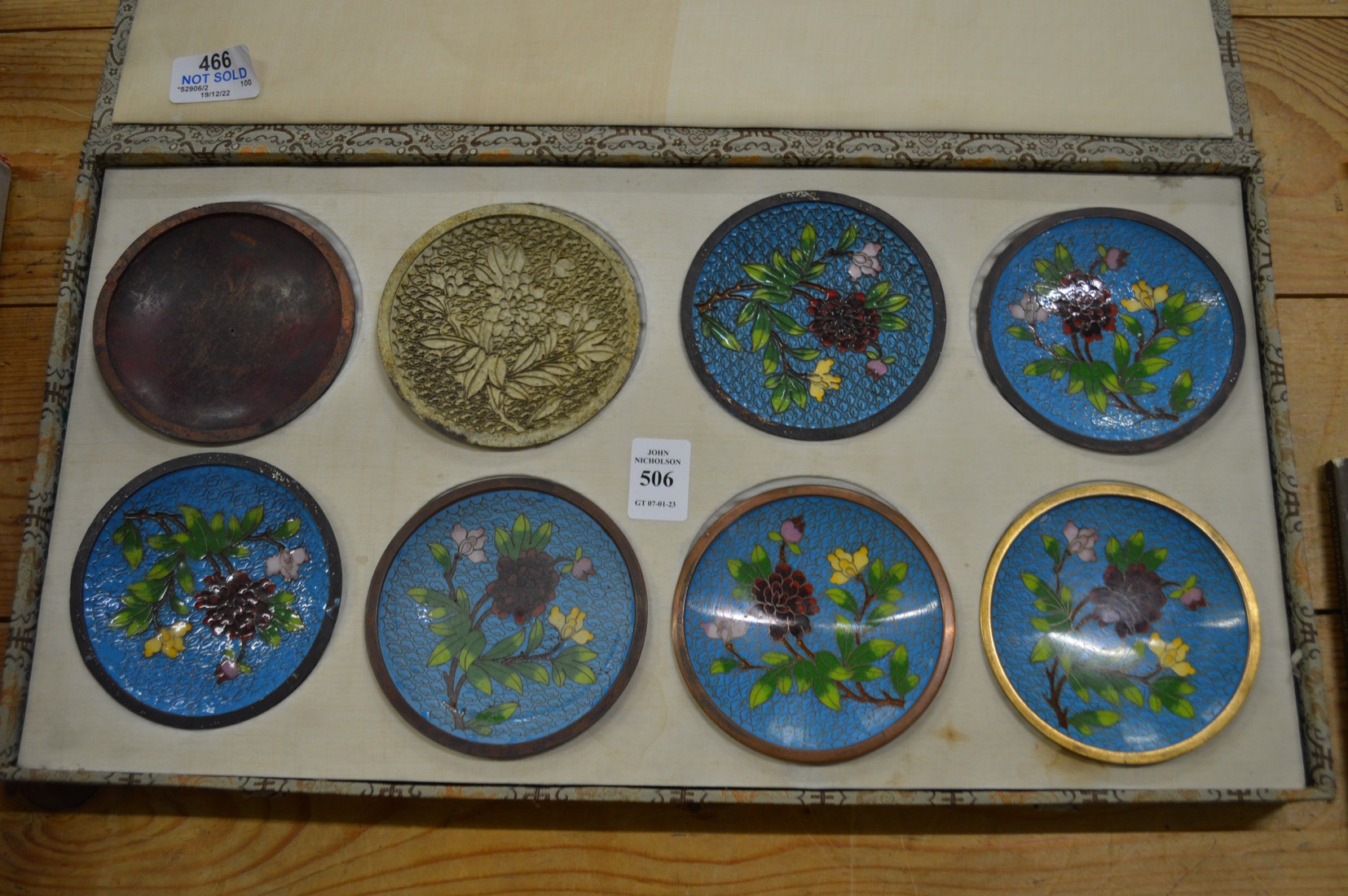 A boxed set of eight Japanese dishes showing the stages of Cloisonne production.