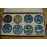 A boxed set of eight Japanese dishes showing the stages of Cloisonne production.